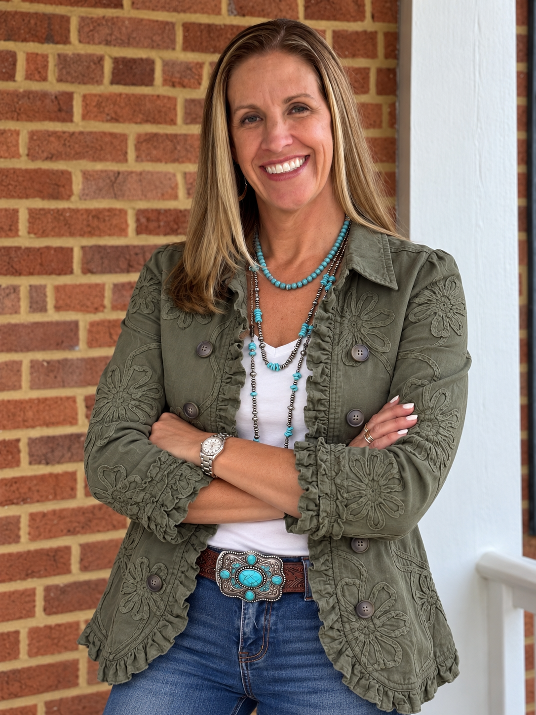 Dr. Gina Casella smiling outdoors beside a brick wall